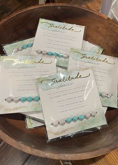 four cards are placed on top of each other in front of a wooden bowl filled with beads