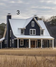 a blue house with white trim and windows in the middle of an open field, surrounded by tall grass