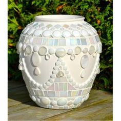 a white vase sitting on top of a wooden table