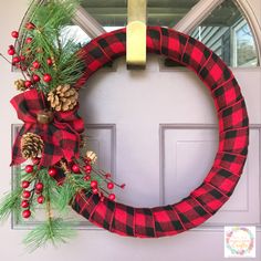 a red and black plaid wreath with pine cones