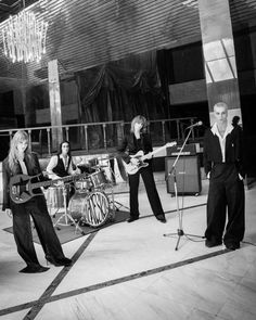 a group of people that are standing in front of microphones and guitar's