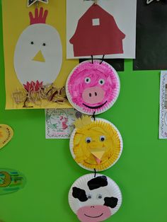 paper plates with farm animals on them hanging from a green wall in front of pictures