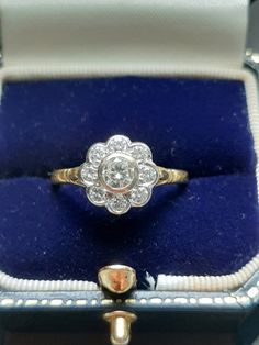 an antique diamond ring sits in a velvet box