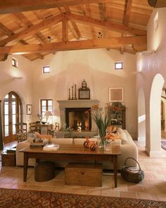 a living room filled with furniture and a fire place in the middle of a room