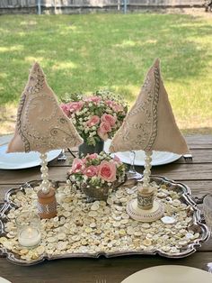 a table with plates, napkins and flowers on it in the shape of sailboats