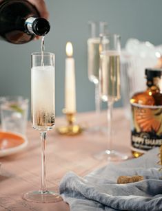 champagne being poured into a glass on top of a table