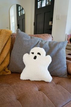 a pillow with a ghost on it sitting on a couch