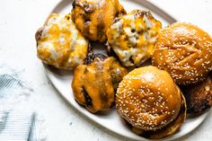 a white plate topped with hamburgers covered in cheese