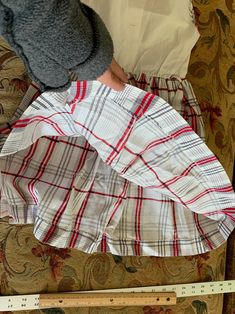 "Vintage cotton dress is made from a white birdseye textured bodice and a red, black, and white gauzy textured skirt gathered into the waist. This same plaid acts as finding along arm holes, neckline and down center front placket, which has 3 decorative black buttons, which look like they may have originally had rhinestones in their centers. It closes with buttons down the center back of bodice- one button is missing. Waistline has a belt carrier on each side. This dress was handmade. Approximat Spring Sleeveless School Uniform Dresses, Plaid Cotton A-line Dress, Fitted Plaid School Dress, Fitted Plaid Dress For School, Plaid Sleeveless School Dress, Sleeveless Plaid School Dress, Preppy Cotton Plaid Dress, Sleeveless Cotton Plaid Dress, White Sleeveless Cotton Plaid Dress