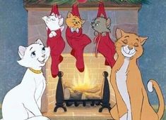 there are many cats that are sitting in front of the fire place with christmas decorations