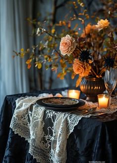 a table topped with a plate and candles next to a vase filled with flowers on top of a table