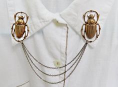 Make any shirt a statement piece with these large scarab collar pins.  they are made with 2 antique brass hollow back and light weight scarab stampings.  they are 43mm long and 28mm wide (1 3/4 inches long and 1 inch wide).  they are connected with 3 antique brass chains measuring 16, 14, and 12 centimeters long and close in the back with a butterfly clasp (pictured).By purchasing this item you agree that you have read and accepted my shop policies :https://www.etsy.com/shop/alapopjewelry/policy Bumble Bee Jewelry, Collar Brooch, Sweater Clips, Creative Shirts, Bee Pin, Chain Collar, Sweater Clip, Collar Chain, Bee Jewelry