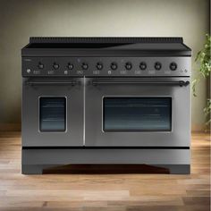 an electric stove with two ovens on the top and one door open, sitting on a wooden floor