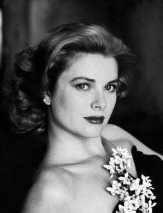 a black and white photo of a woman with flowers in her hair