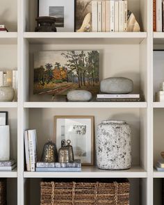 a white book shelf filled with lots of books and vases on top of it