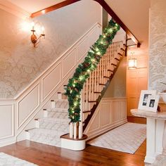 a staircase decorated with christmas garland and lights