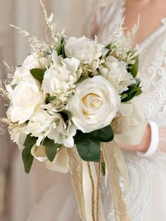 a bridal bouquet with white flowers and greenery