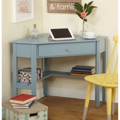 a laptop computer sitting on top of a blue desk in front of a yellow chair