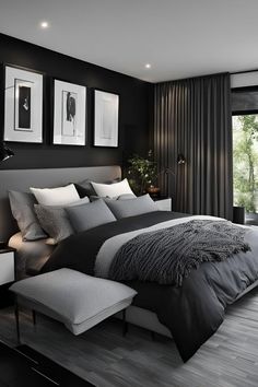 a bedroom with black walls and white bedding is pictured in this image, there are two framed pictures on the wall above the bed