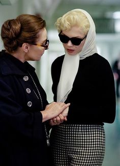 two women standing next to each other wearing sunglasses