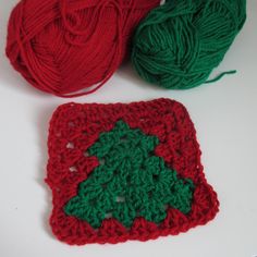 two balls of yarn are sitting next to each other on a white surface with green and red crochet