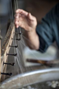 a person is working on some kind of object with metal rods attached to the wall