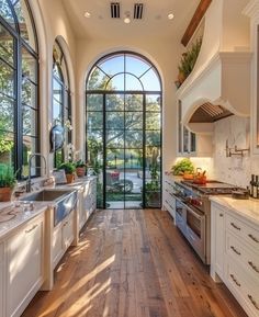 a large kitchen with an arched window and wooden floors