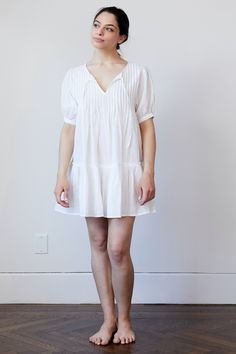 Cotton Voile is a weightless fabric that feels good next to your skin. Move over baggy, shapeless t-shirt that you have been sleeping in, our Pin Tuck Dress is taking your place. The tissue like feel of our 100% cotton is perfect for sleeping in. We have designed it hardware free so no matter how much you toss and turn you will always be comfortable. Available in three slumber ready shades, White, Black and Peony ♦︎ Fabric: 100% Sheer Cotton Voile ♦︎ Pin tucked across chest with simple tie closure ♦︎ Button on sleeve and raw edge on top seam of ruffle skirt Fit Comments ♦︎Fits true to size ♦︎ Cut to be full. Size down for more fitted look ♦︎ Model is size 4 and wearing a small Care instructions ♦︎Machine wash gentle cycle or hand wash ♦︎Do not bleach ♦︎Dry flat ♦︎Cool iron or use steamer White Relaxed Fit Dress With Puff Sleeves, White Billowy Short Sleeve Dress, White Relaxed Fit Sleep Dress, Tuck Dress, Chest Opening, Sleep Dress, Cotton Voile, Look Plus, Pin Tucks