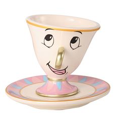 a ceramic cup and saucer with a face on it