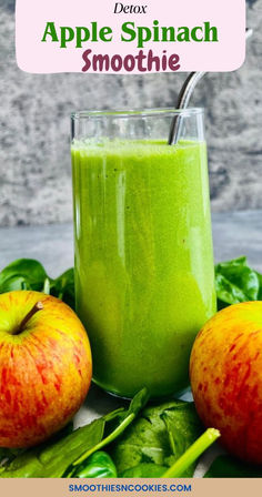 an apple spinach smoothie in a glass next to two apples