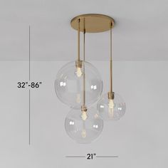 three clear globes hanging from the ceiling with measurements for each light bulb and height