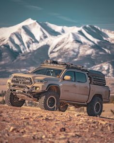 the truck is parked in the desert with mountains in the background