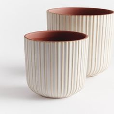 two white and brown vases sitting next to each other