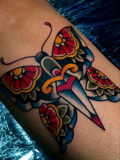 an artistic tattoo design on the leg of a woman's arm with scissors and flowers