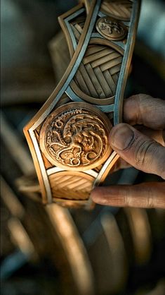 a person is holding a wooden object in their hand and it looks like an intricate design