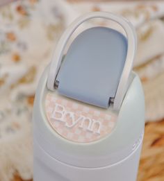 a close up of a plastic container on a table with a quilt in the background