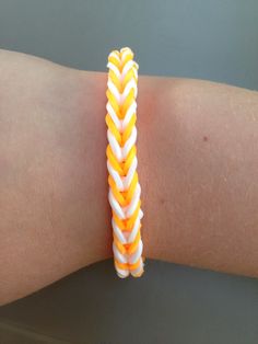 an orange and white bracelet on someone's arm