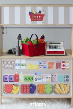 a toy kitchen with fruits and vegetables on the shelves