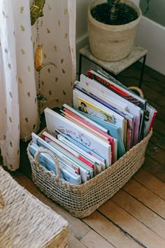 a basket filled with books next to a window