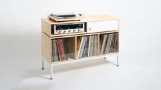 a record player is sitting on top of a shelf with records and cds in it