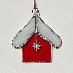 a red and white stained glass house ornament