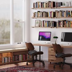 a desk with two computer monitors on top of it next to a book shelf filled with books