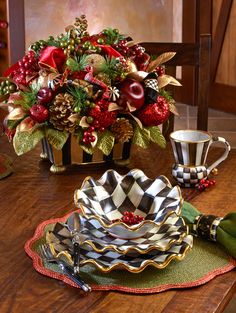 a wooden table topped with plates and bowls filled with christmas decorations on top of it