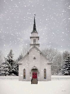 a white church with a red door in the snow