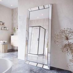 a bathroom with a large mirror on the wall and a bathtub in the background