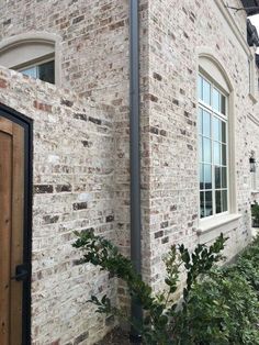 a brick building with white windows and wooden door