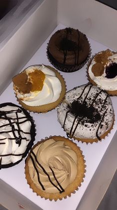 a box filled with different types of cupcakes