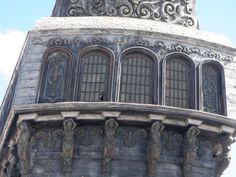 the top of a building with an ornate design on it's sides and windows