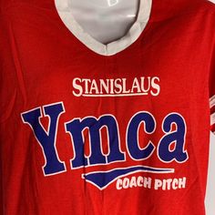 a t - shirt with the words yymca on it is hanging on a hanger