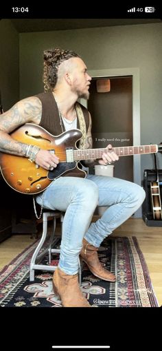 a man sitting on top of a chair holding a guitar